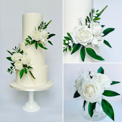 3 tier all white wedding cake with 5 white sugar roses