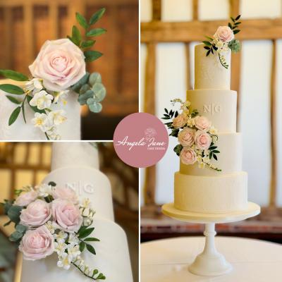 Stunning pale pink sugar roses to adorn an all white wedding cake, featuring the couples initials